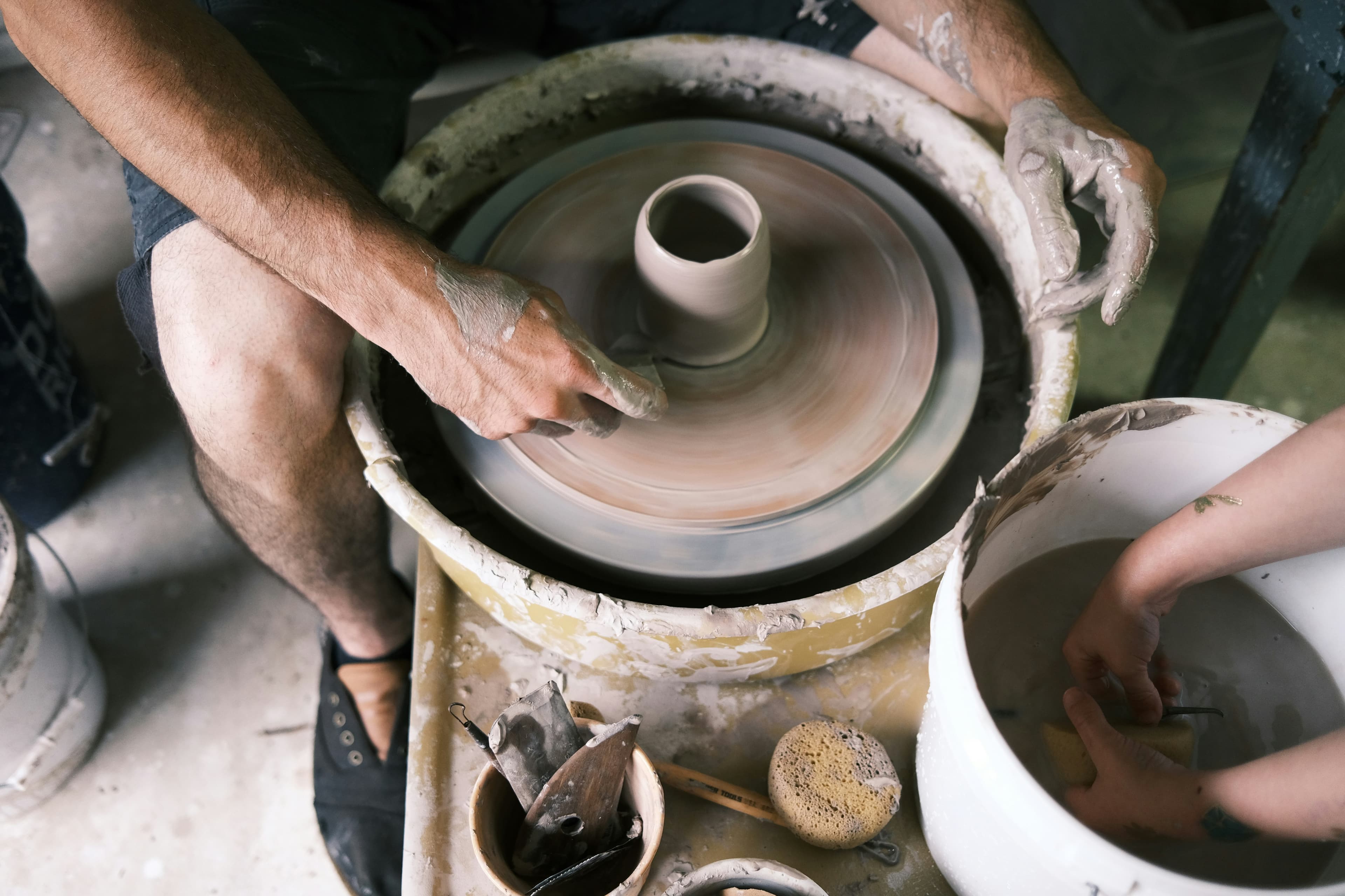 Person shaping clay on pottery wheel with hands