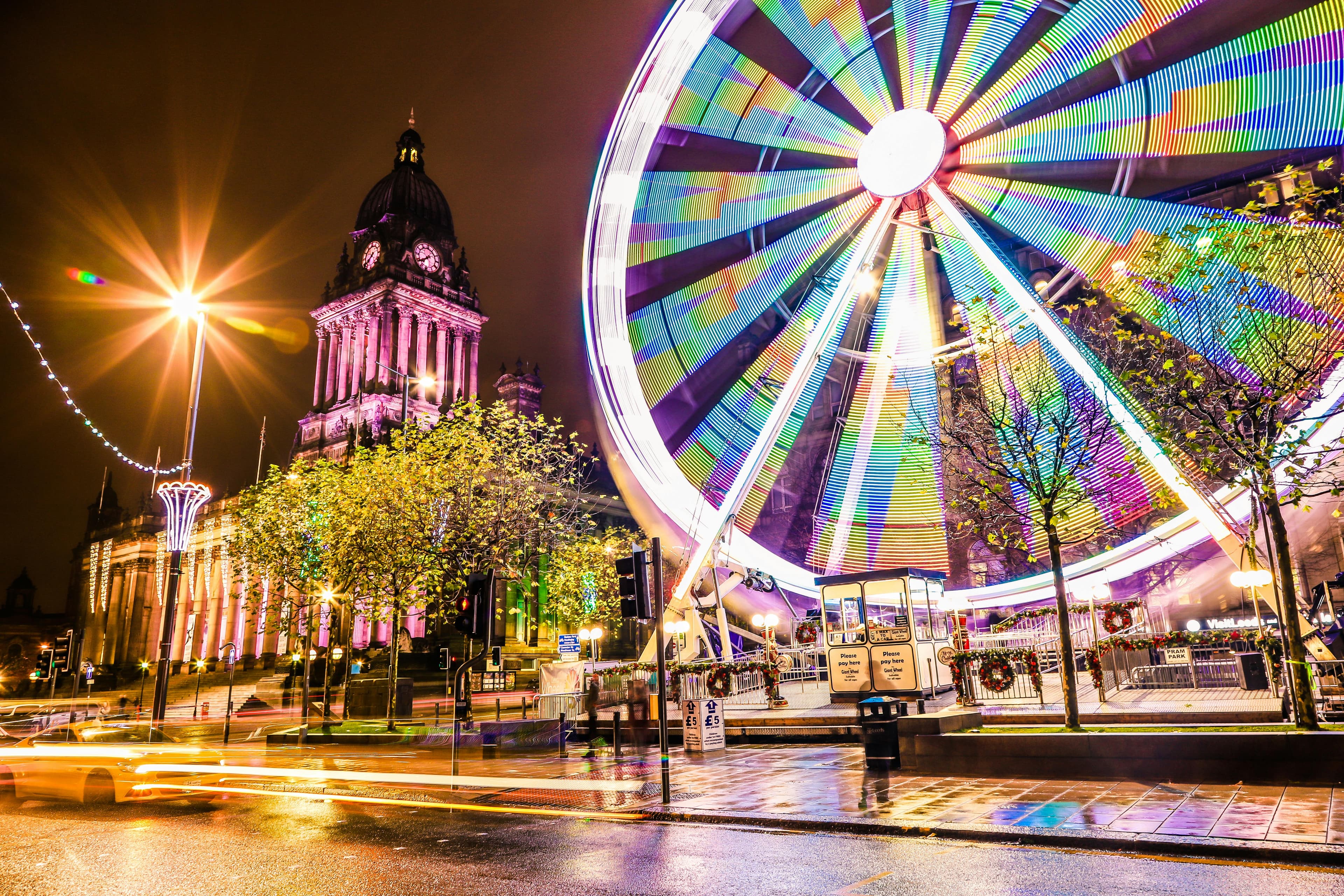 Leeds city centre at night with illuminated ferris wheel and Town Hall